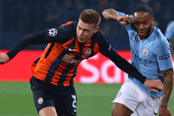 Mykola Matviyenko ของ Shakhtar Donetsk ต่อสู้เพื่อลูกบอลโดยมีคู่แข่งอยู่ข้างหลังเขา